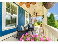 Inviting front porch featuring comfortable wicker seating, ceiling fans, and beautiful landscaping at 1575 Riverwalk Pkwy, Rock Hill, SC 29730