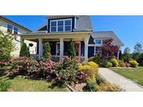 Inviting home featuring a charming front yard with colorful flowers and a covered front porch at 1575 Riverwalk Pkwy, Rock Hill, SC 29730