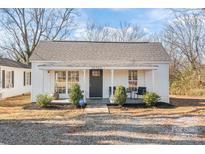 Charming single-story home featuring a covered front porch with seating and a well-maintained front yard at 19705 S Ferry St, Cornelius, NC 28031