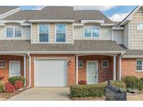 Brick front exterior of townhome with attached garage and landscaping at 315 Valley Brook Se Ln, Concord, NC 28025