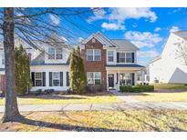 Two-story brick townhouse with front porch and landscaping at 9813 Hanberry Blvd, Charlotte, NC 28213