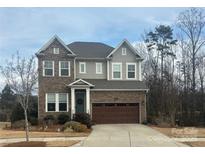 Two-story home with brick and gray siding and a two car garage and landscaping at 1124 Greenbridge Dr, Matthews, NC 28105
