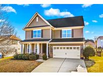 Two-story house with a large front porch, two-car garage, and well-manicured lawn at 138 Byers Commons Dr, Mooresville, NC 28117
