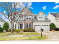 Two-story house with brick and siding exterior, two-car garage, and landscaping at 1458 Bedlington Nw Dr, Charlotte, NC 28269