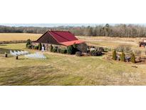 Aerial view of a rustic barn venue with surrounding fields and landscaping at 15554 Highway 601 S Hwy, Midland, NC 28107