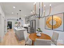 Well-lit kitchen features gray cabinetry, stainless steel appliances, an island, and a dining area at 625 Colorado Ave # A, Charlotte, NC 28206