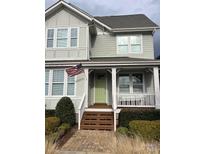 Charming two-story home with welcoming porch and an American flag at 746 Waterscape Ct, Rock Hill, SC 29730