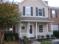 Inviting home featuring a cozy front porch and complementary landscaping at 8272 Golf Ridge Dr, Charlotte, NC 28277