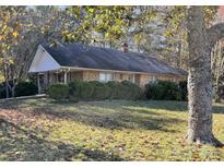 Brick ranch house with covered porch and mature trees in the yard at 8725 Bringle Ferry Rd, Salisbury, NC 28146