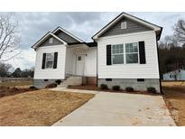 Newly constructed home with gray and white siding, a concrete driveway, and landscaping at 1307 Signal Ave, Gastonia, NC 28052