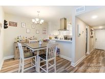 Bright dining area with a wet bar and modern light fixture adds charm to this inviting space at 1605 Merry Oaks Rd # E, Charlotte, NC 28205