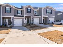 Gray townhouses with white garage doors and landscaping at 3021 Belstock Ct, Charlotte, NC 28216