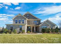 Two-story home with gray brick and siding, landscaping, and a large yard at 501 Alucio Ct, Matthews, NC 28104