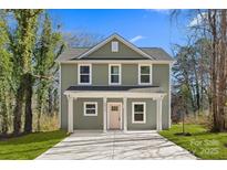 Charming two-story home featuring a welcoming front porch and a freshly poured concrete driveway at 5812 Torrence St, Charlotte, NC 28269