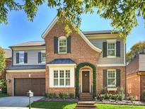 Brick two-story home with shutters, landscaping, and a two-car garage at 6819 Conservatory Ln, Charlotte, NC 28210