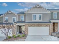 Two-story townhome with gray siding, stone accents, and a two-car garage at 8119 Merryvale Ln, Charlotte, NC 28214