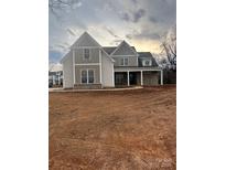 Two-story home with gray and beige siding, covered porch, and unfinished yard at 3428 Greene Rd, Monroe, NC 28110