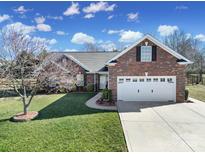 Charming brick home featuring an attached two-car garage, well-maintained lawn, and mature landscaping at 849 Treva Anne Sw Dr, Concord, NC 28027