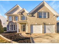 Two-story brick home with a two-car garage and landscaped yard at 8835 Merrie Rose Ave, Charlotte, NC 28213