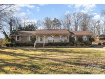 Brick ranch house with covered porch and spacious lawn at 1318 Gum Branch Rd, Charlotte, NC 28214