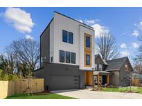 Modern three-story home featuring a two-car garage and stylish architectural details at 3132 Carol Ave, Charlotte, NC 28208