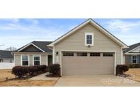 A well-maintained home features a beige two-car garage with a classic design at 5025 Macvittie Ln, Charlotte, NC 28214