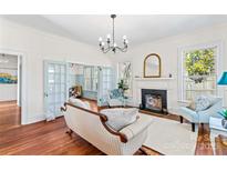 Inviting living room features hardwood floors, fireplace, elegant lighting, and French doors to adjoining spaces at 506 S Church St, Salisbury, NC 28144
