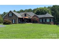 Charming two-story stone and brick home featuring a landscaped yard and covered front porch, perfect for relaxing outdoors at 5645 White Store Rd, Wingate, NC 28174