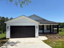 Charming single-story home with a black garage door, black accents, and manicured lawn at 106 Gilliatt St, Shelby, NC 28150