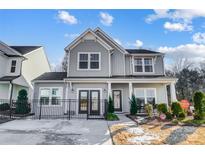 Two-story home with gray siding, double doors, and a black fence at 128 Shay Crossing Rd, Salisbury, NC 28146