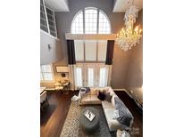Bright living room featuring a large window, chandelier, and comfortable seating at 128 Steinbeck Way # E, Mooresville, NC 28117