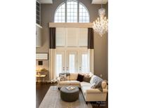 Bright living room with large windows, elegant chandelier, and comfortable seating area at 128 Steinbeck Way # E, Mooresville, NC 28117