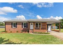 Brick ranch home with a covered porch, new landscaping, and a carport at 2525 Oxford Cir, Lancaster, SC 29720