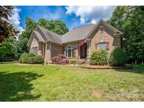 Brick home with landscaped yard, shutters, and American flag at 119 Barton Pl, Mooresville, NC 28117