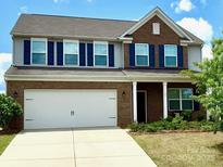 Charming two-story home featuring a two-car garage, brick accents, and a well-maintained lawn at 121 Mackinac Dr, Mooresville, NC 28117