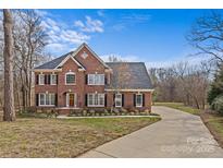 Brick two-story house with a paved driveway and landscaping at 2050 Stoney Creek Nw Dr, Concord, NC 28027