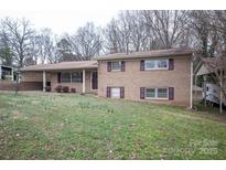 Brick two story home with carport, mature trees, and partial dormant lawn at 2905 Maryland Ave, Kannapolis, NC 28083