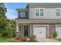 Two-story townhome with gray siding, stone accents, and a two-car garage at 33 Woodsdale Se Pl, Concord, NC 28025