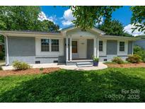 Charming single-story home featuring a well-manicured lawn, painted brick, and a welcoming front porch at 3531 Enfield Rd, Charlotte, NC 28205
