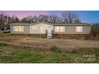 Tan, single-story home with symmetrical windows, white trim, and a small porch at 354 Baptist Church Rd, Gold Hill, NC 28071