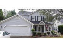 Two-story house with gray siding, a white garage door, and a front porch at 5711 Falls Ridge Ln, Charlotte, NC 28269