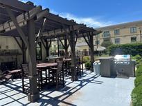 Community grilling area with tables, chairs, and pergola at 721 Governor Morrison St, Charlotte, NC 28211