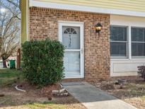 Brick front exterior of home with a gray door and landscaping at 7530 Holly Grove Ct, Charlotte, NC 28227