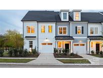 Two-story townhome with gray and white exterior, attached garage, and landscaping at 9316 Munsing Dr # 145, Charlotte, NC 28269