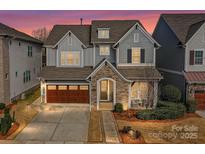 Charming two-story home with stone accents, a two-car garage, and a well-manicured front yard at 9730 Briarwick Ln, Charlotte, NC 28277