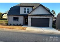 Two-story house with gray siding, dark garage door, and a neatly landscaped yard at 1057 12Th Avenue Nw Dr, Hickory, NC 28601