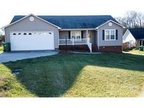 Ranch style home with attached garage and landscaped lawn at 1243 Glory Ct, Oakboro, NC 28129