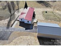 Aerial view of a single-story home with red metal roof and detached garage at 291 Patterson Farm Rd, Mooresville, NC 28115