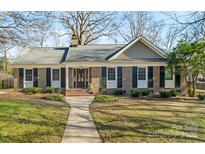 Charming brick home featuring manicured landscaping, black shutters, and a welcoming walkway to the front door at 3939 Sussex Ave, Charlotte, NC 28210