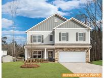 Two-story house with gray siding, stone accents, and a white garage door at 6332 Honor Ave, Midland, NC 28107